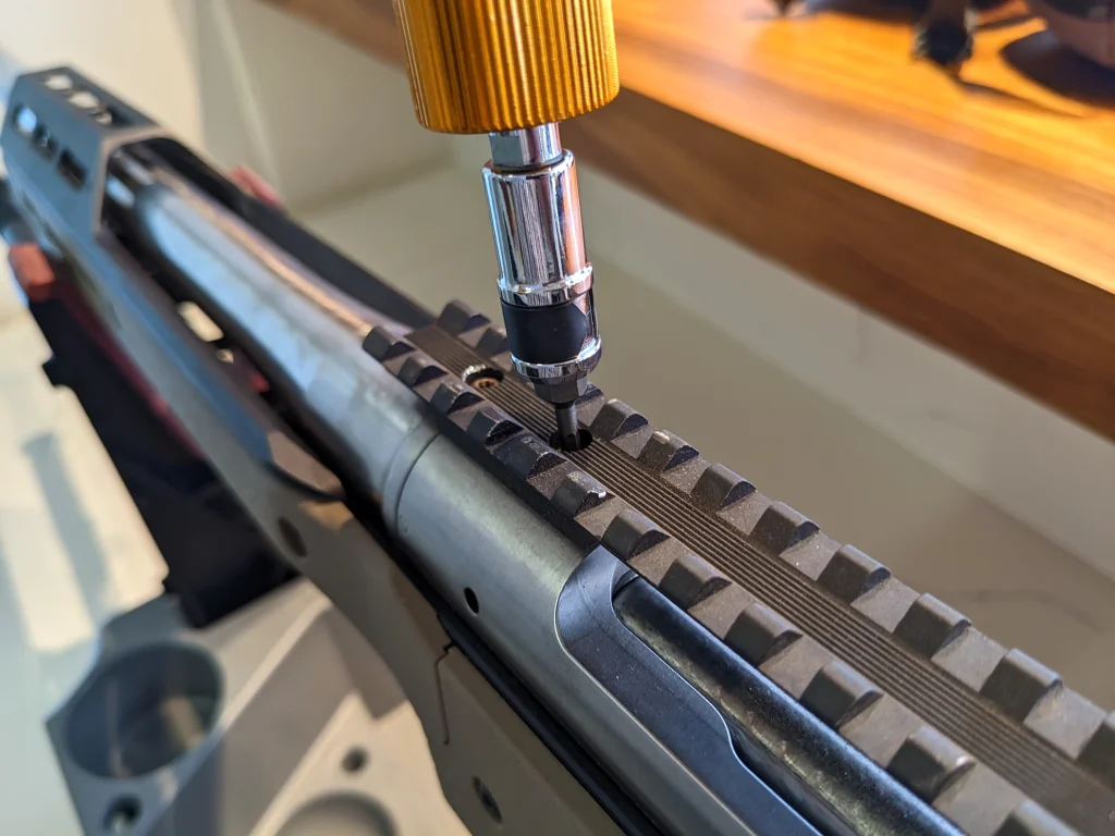 Close-up of a gun torque wrench being used on a firearm component.