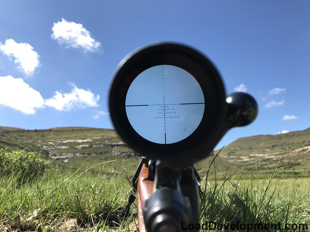 Reticle view of a hunting scope glassing a mountain side for antelope.
